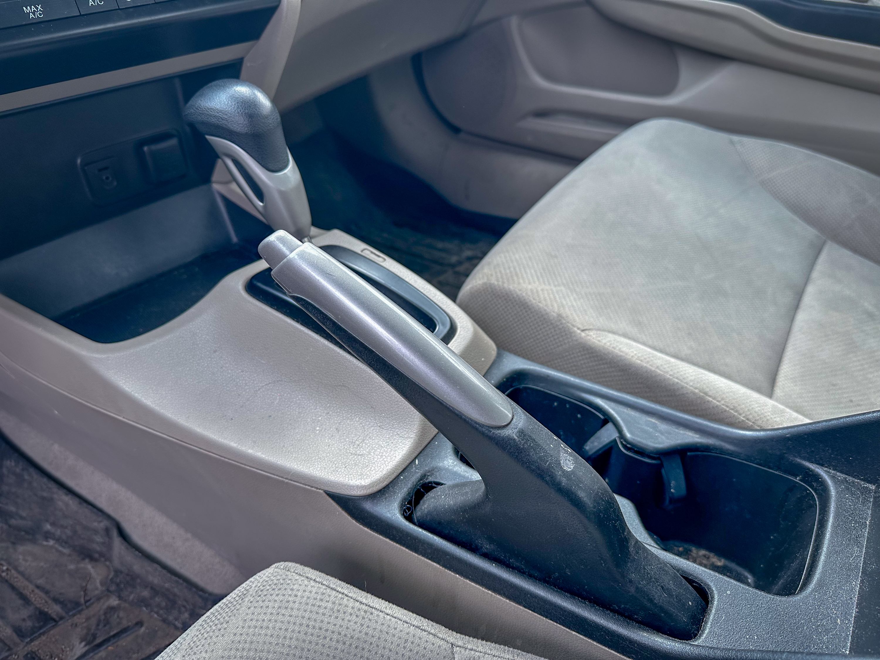 A photo of the center console of the Honda Civic, showing the parking brake in its on position