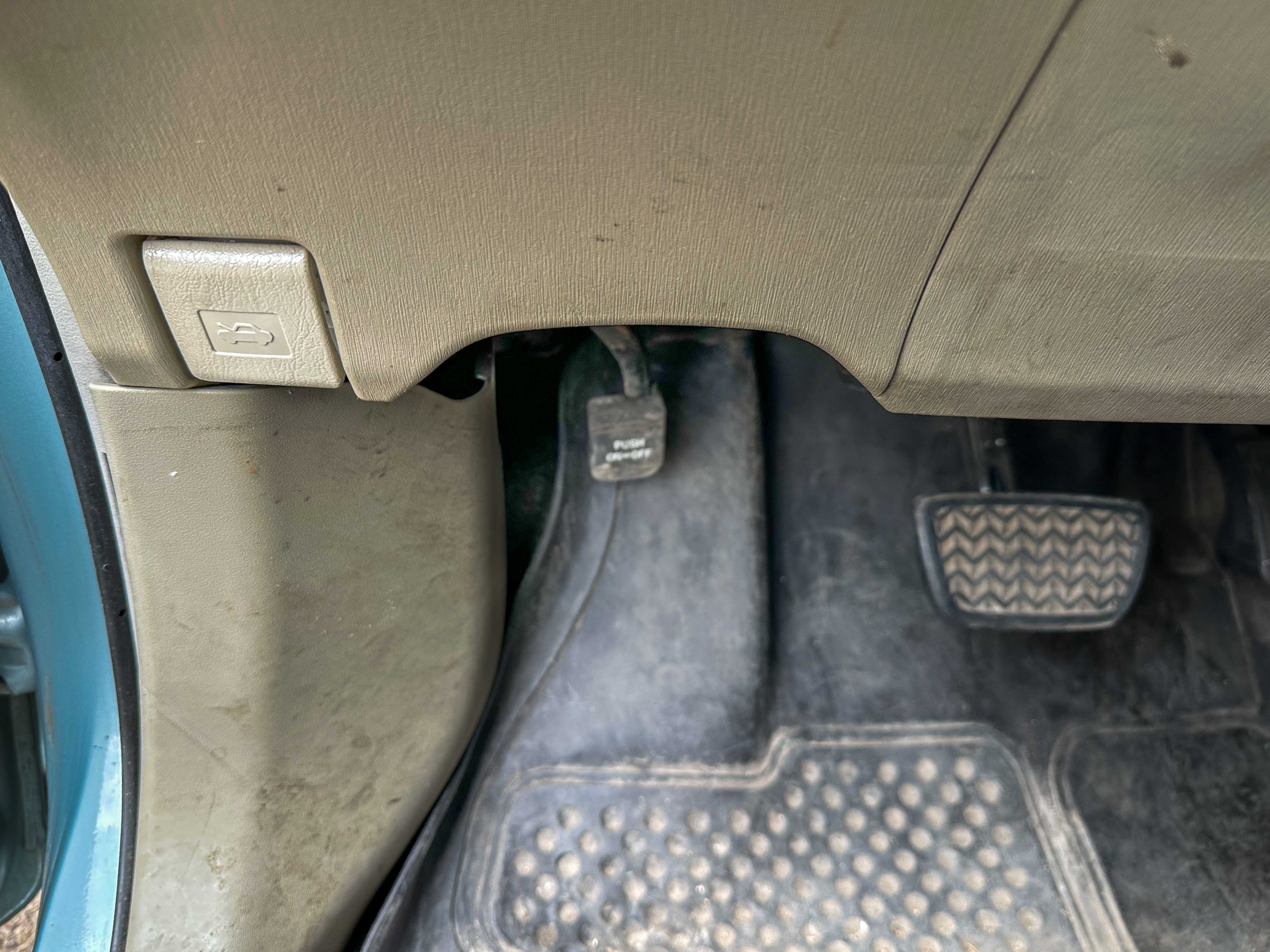 A photo of the Toyota Prius parking brake pedal in its on position, located near the gas and brake pedals